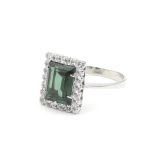 Ring i 18k guld med zirkon stenar och en grön sten