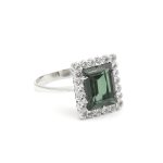 Ring i 18k guld med zirkon stenar och en grön sten