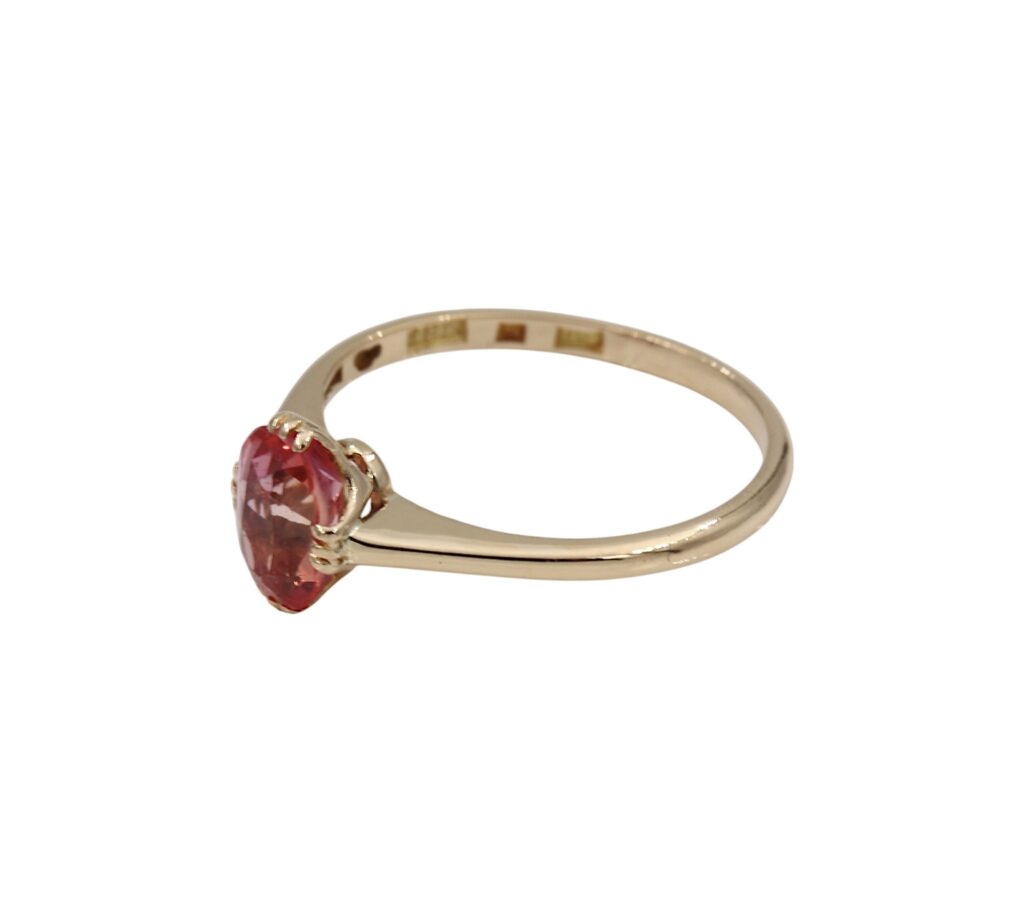 Ring i 18K guld med en rosa/röd sten