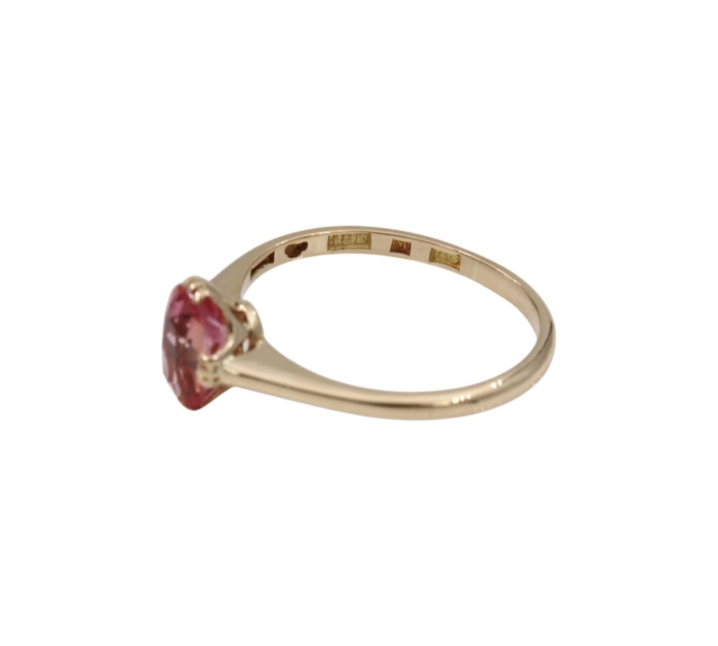 Ring i 18K guld med en rosa/röd sten