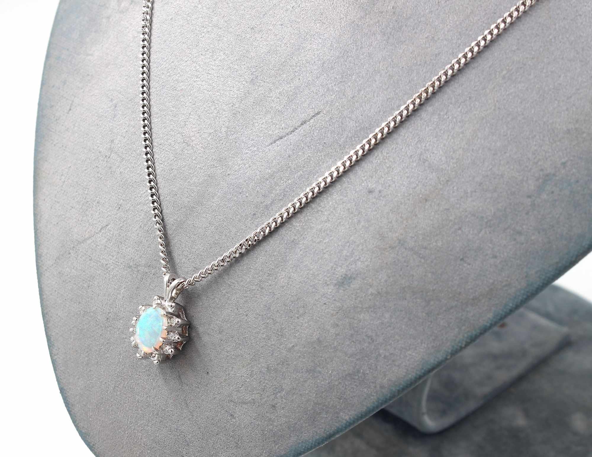 Halsband med ett hänge i 18K vitguld med opal och diamanter.