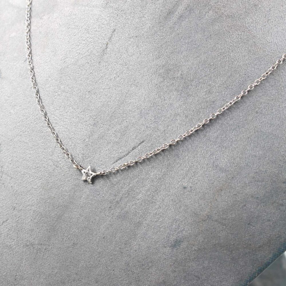 Halsband i 18k vitguld med en stjärna och en liten diamant i mitten.