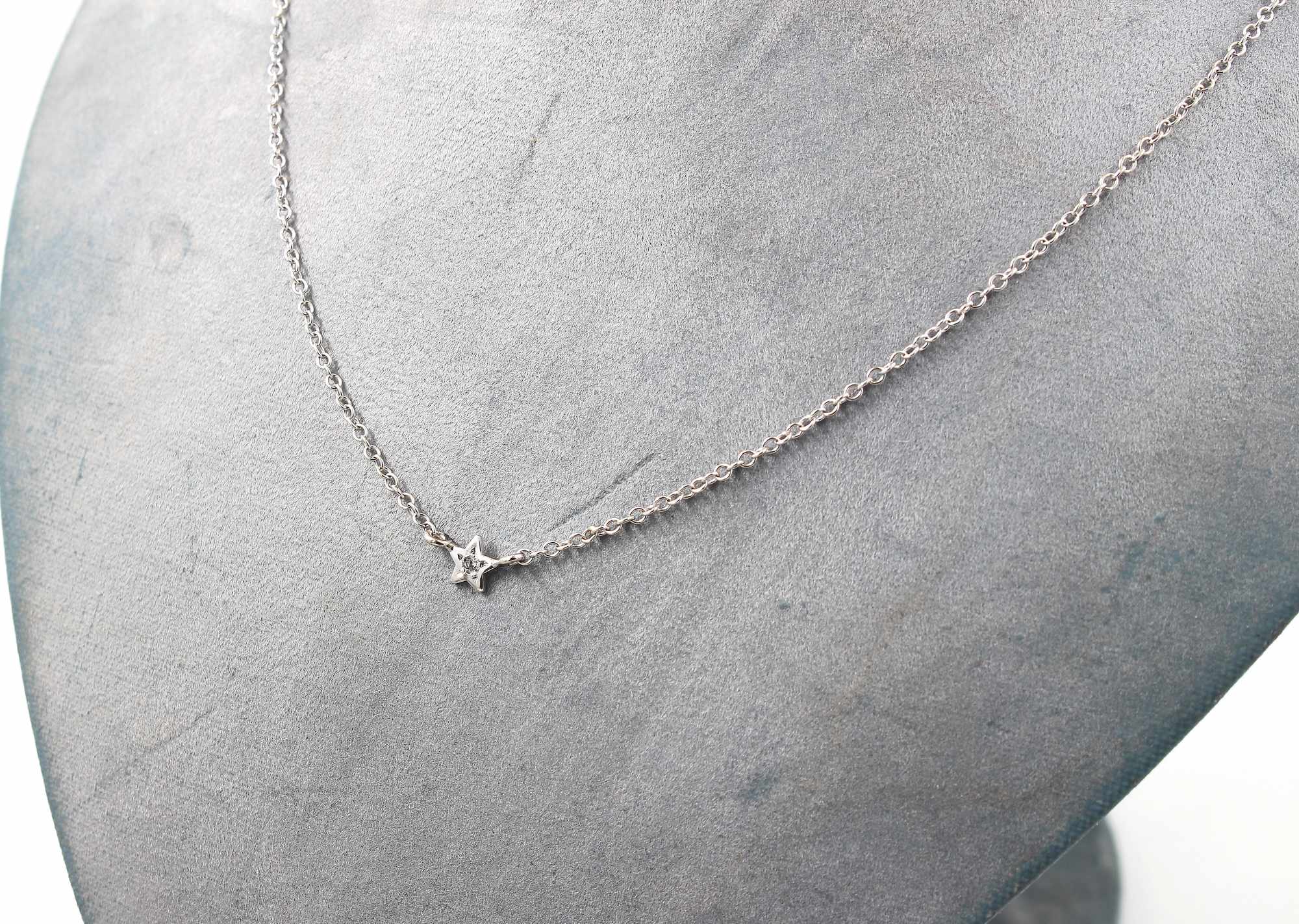 Halsband i 18k vitguld med en stjärna och en liten diamant i mitten.