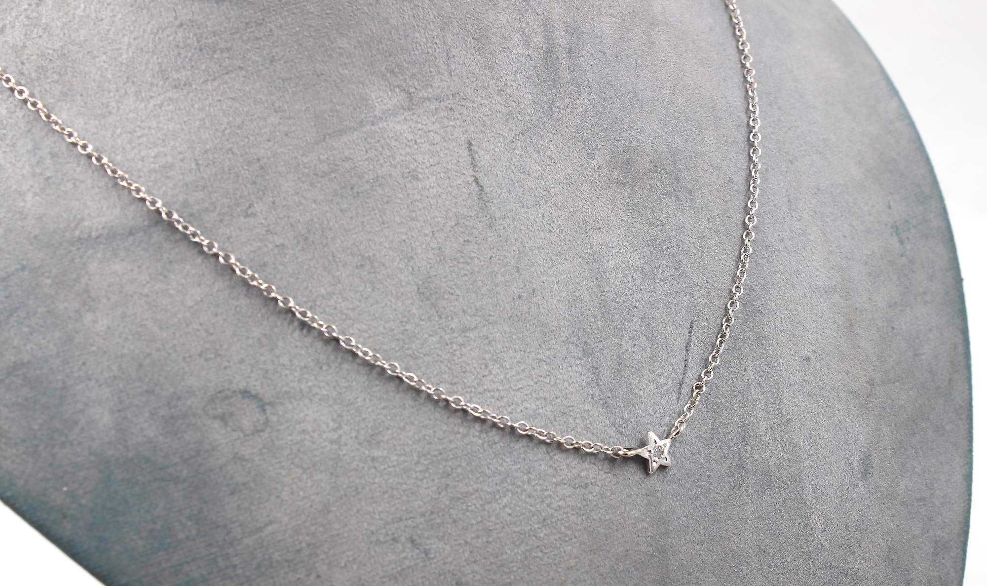 Halsband i 18k vitguld med en stjärna och en liten diamant i mitten.