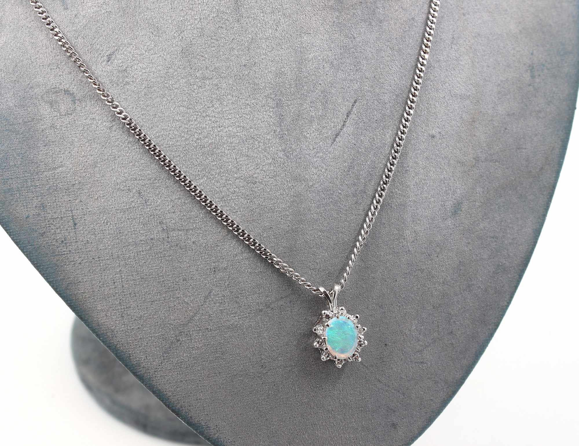 Halsband med ett hänge i 18K vitguld med opal och diamanter.